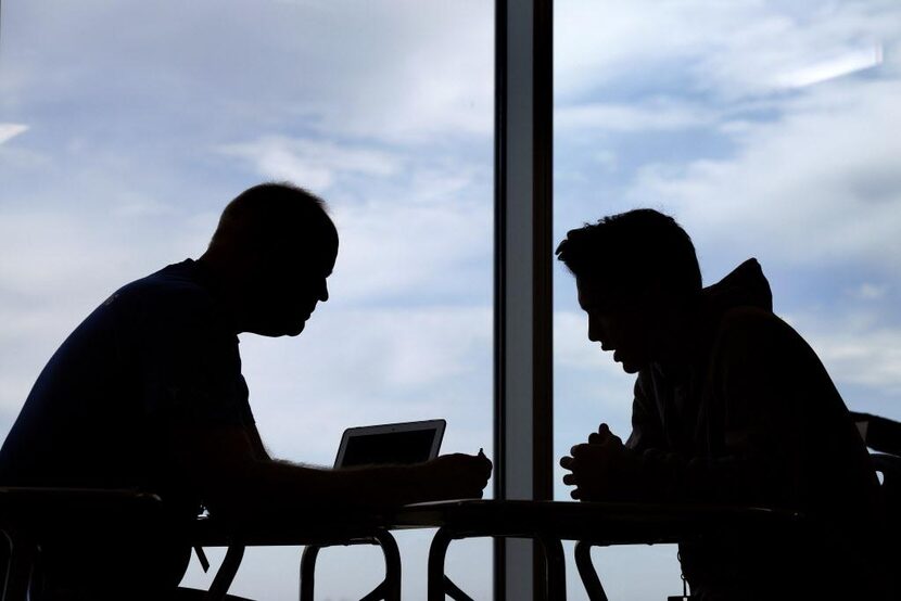 Al Marks, consejero estudiantil de la preparatoria Grand Prairie, platica con William...