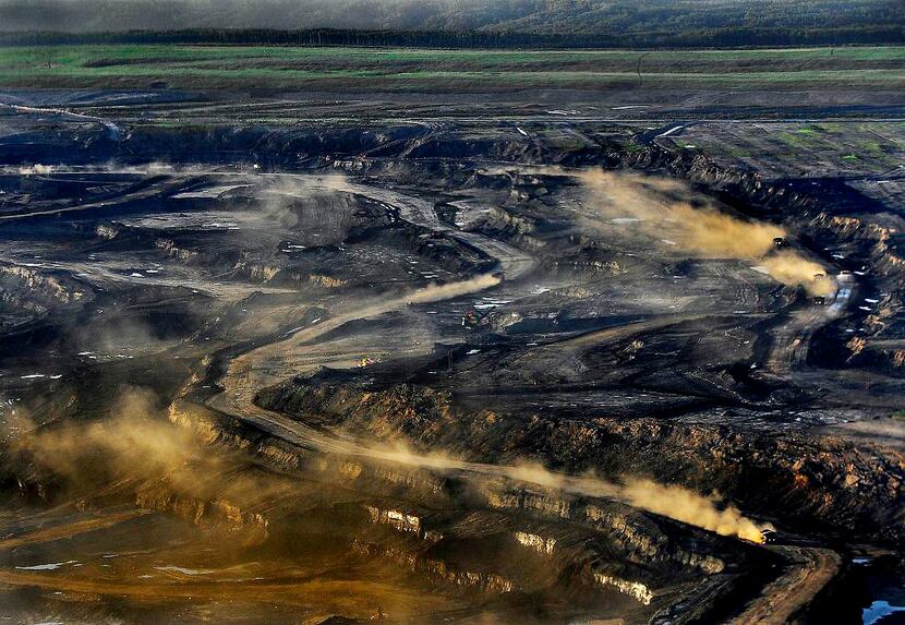 Dust rises from the Alberta, Canada, oil sands project of Syncrude, which is partly owned by...
