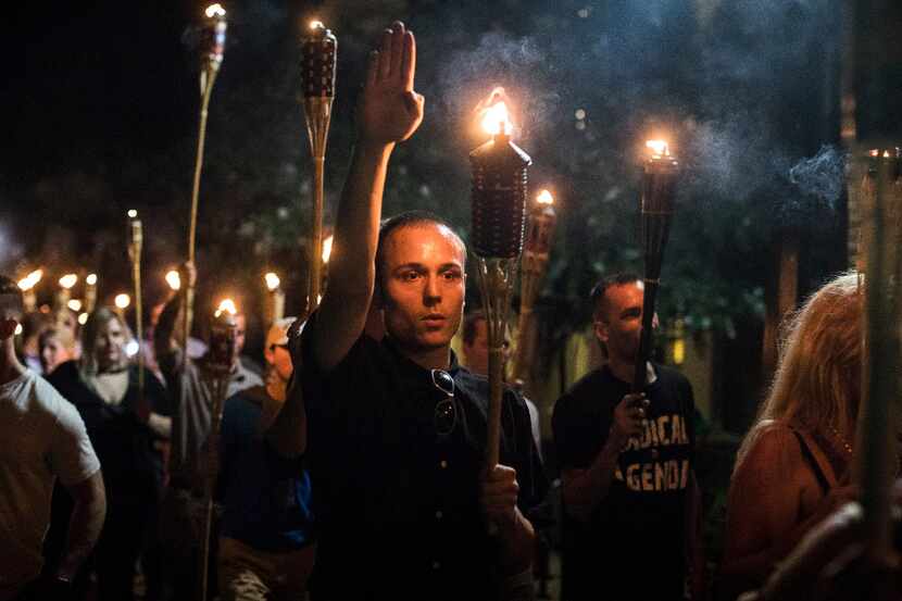 Torch-bearing white nationalists rally around a statue of Thomas Jefferson near the...
