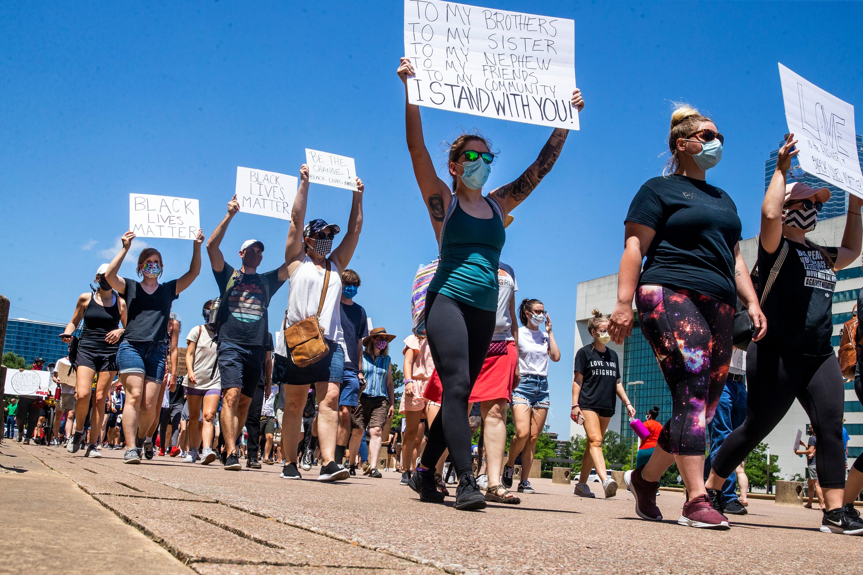 Protesters march in a silent demonstration at Dallas City Hall to denounce police brutality...