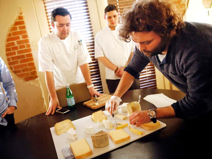Travis Hughes (right), a cheese specialist at Regalis Texas, assembles a platter of cheeses...