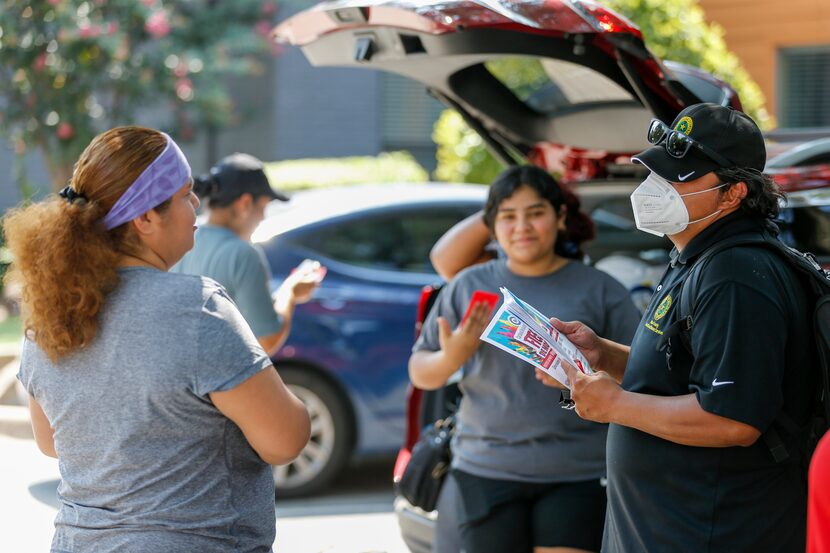 Armando Martinez, Dallas County Health & Human Services community liaison, speaks with...