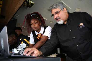 Karim Virani, director of technology for Big Thought, helps eighth-grader India Anderson at...