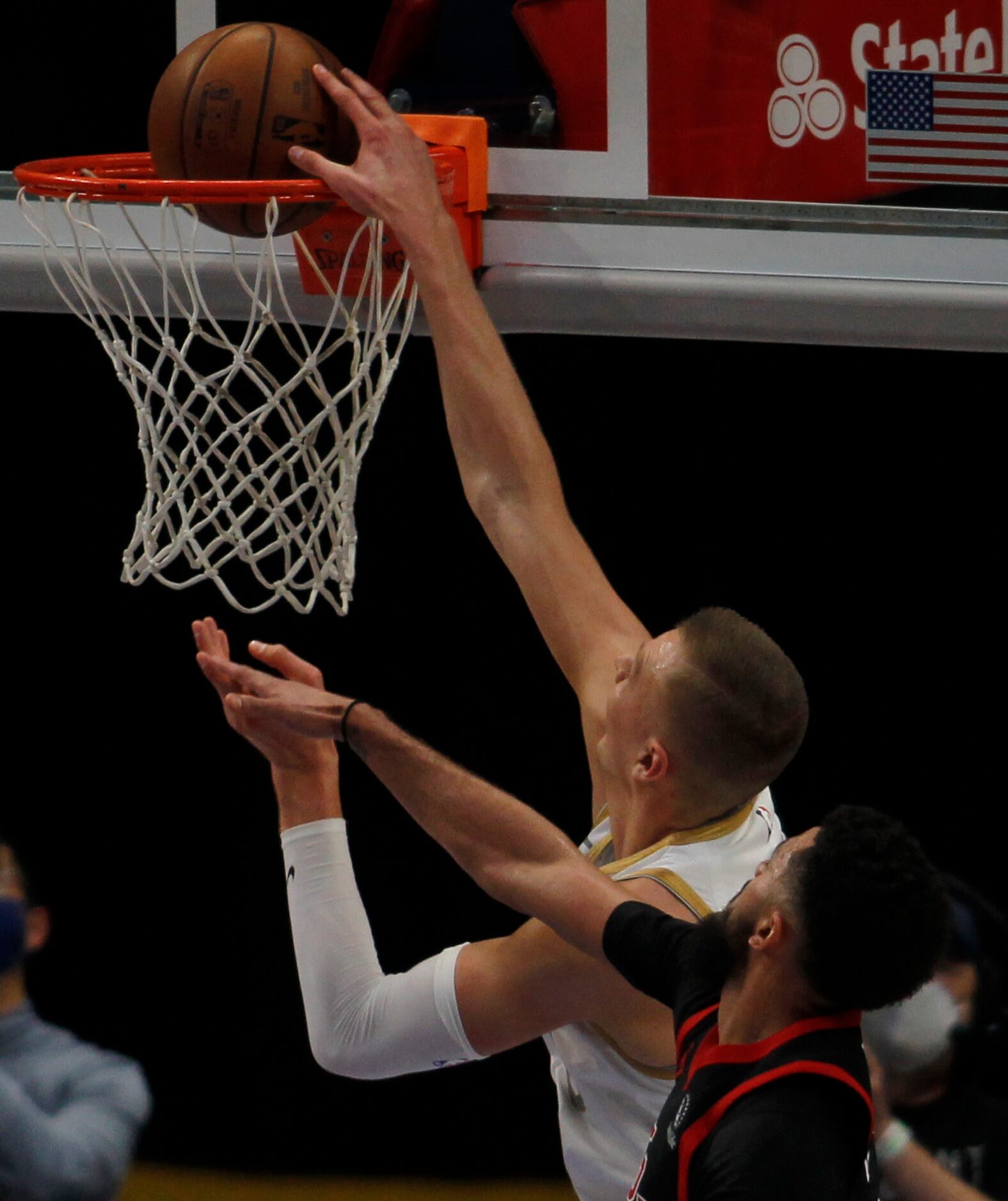 Dallas Mavericks center Kristaps Porzingis (6) tips in a shot over the defense of Toronto...