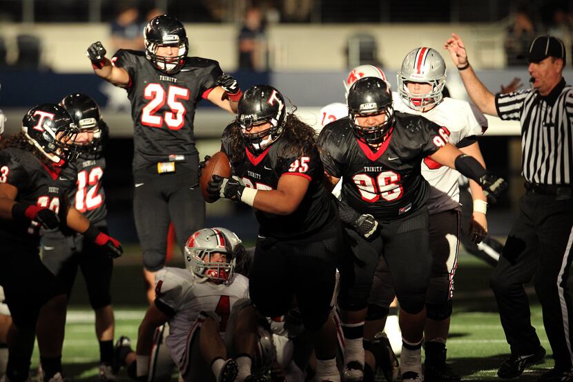 Euless Trinity DL Hafoka Olie (95) scoops up a fumble by Flower Mound Marcus QB Ryan Vaughn...