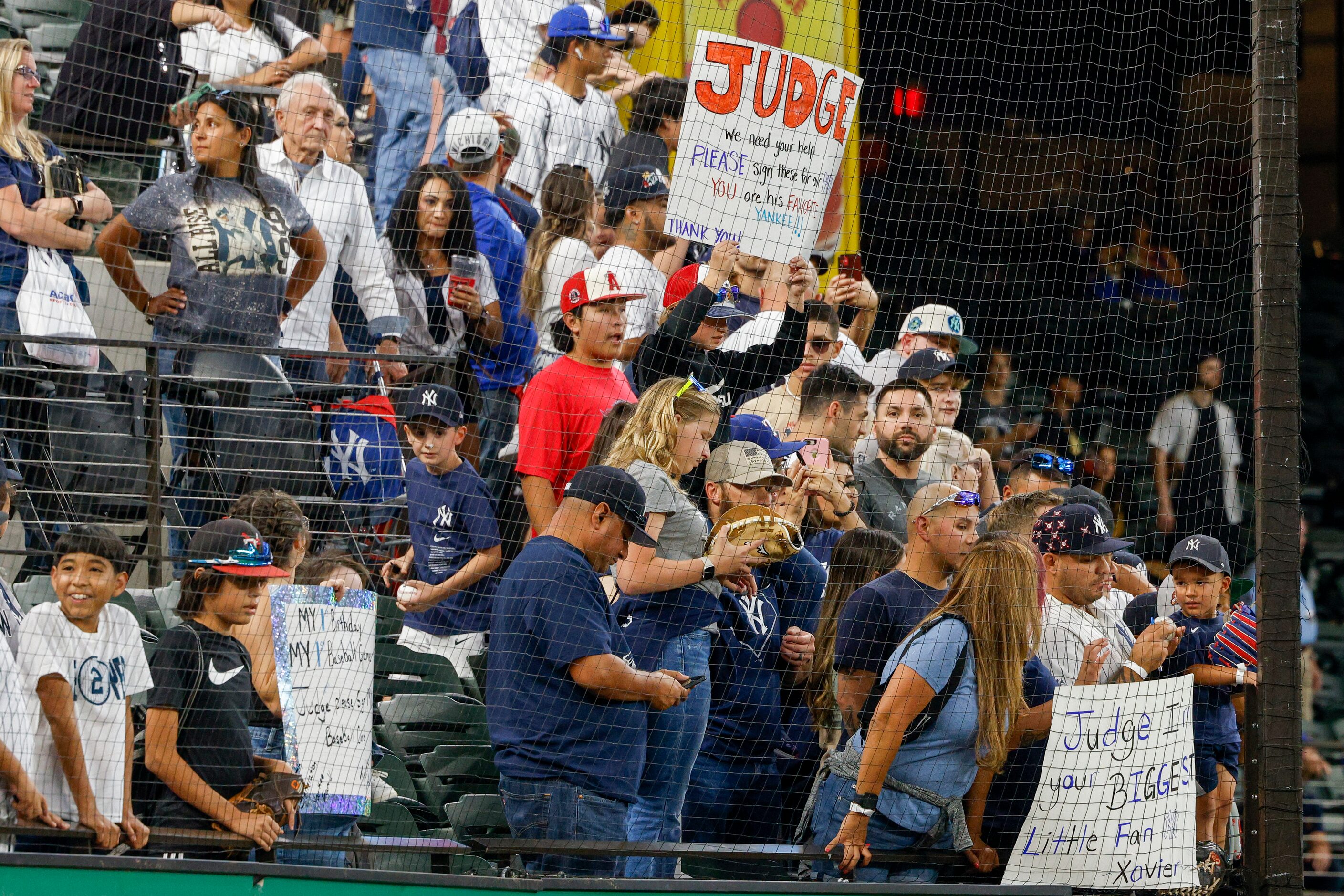 Fans hold signs before a MLB game between the New York Yankees and Texas Rangers at Globe...