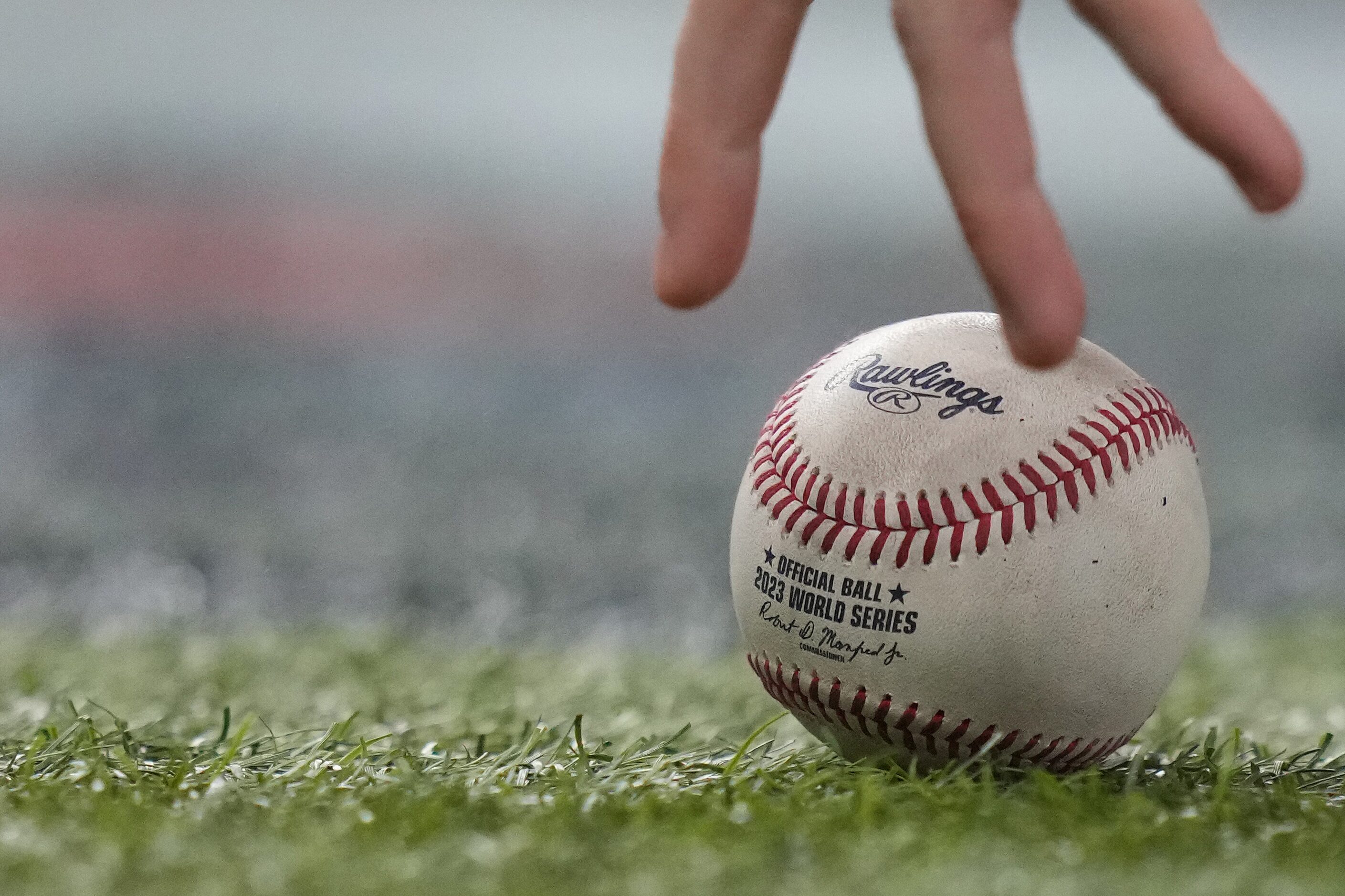 A bat boy picks up a foul ball hit by Texas Rangers' Nathaniel Lowe during the third inning...