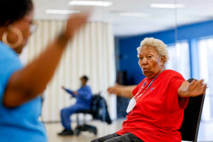 Dallas resident Mary Bennett (right) follows instructor Angela White during a chair exercise...