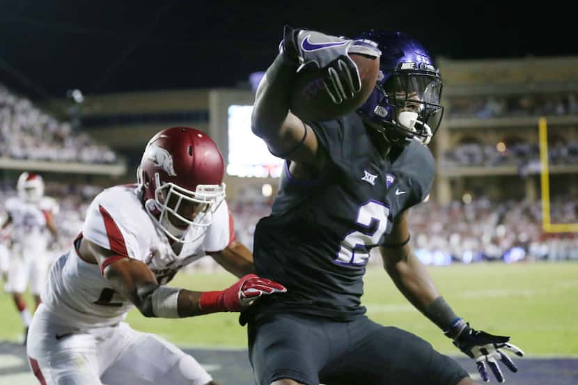 TCU wide receiver Taj Williams (2) catches the ball while being defended by Arkansas...