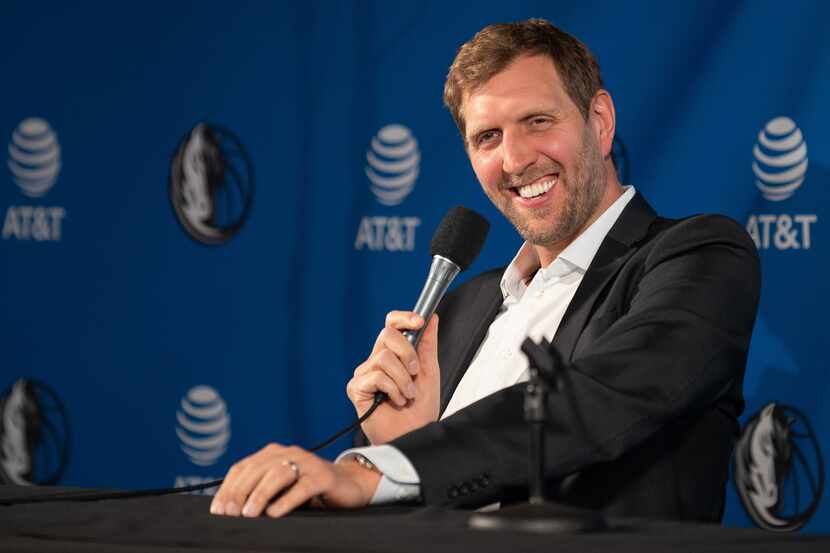 Former Dallas Mavericks player Dirk Nowitzki reacts with laughter while answering a question...