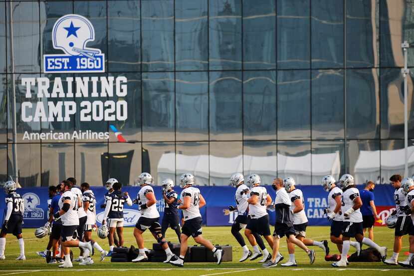 Cowboys players make their way to the field for practice during training camp at The Star in...