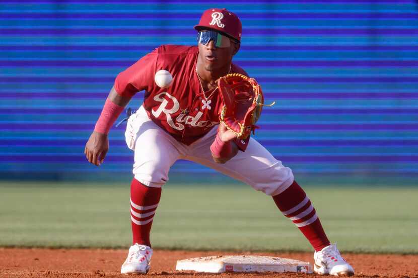 Frisco RoughRiders infielder Luisangel Acuña warms up during inning break during a baseball...