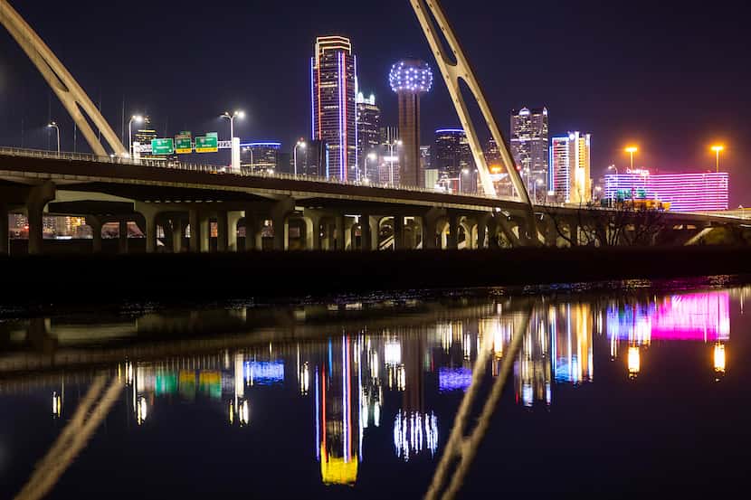 The downtown Dallas skyline is seen behind the Margaret McDermott Bridge lit in Southwest...