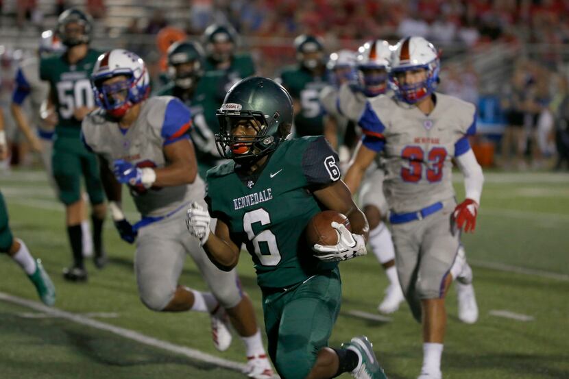 Kennedale's Cameron Hynson (6) gains yards against Midlothian Heritage during the first half...