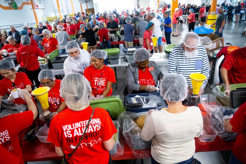 Volunteers from Macy's package food as they volunteer at North Texas Food Bank in Plano on...