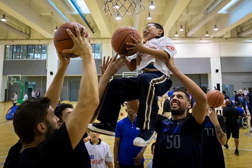 Dallas Mavericks center Salah Mejri (50) lifts a Special Olympian so he can dunk the ball...
