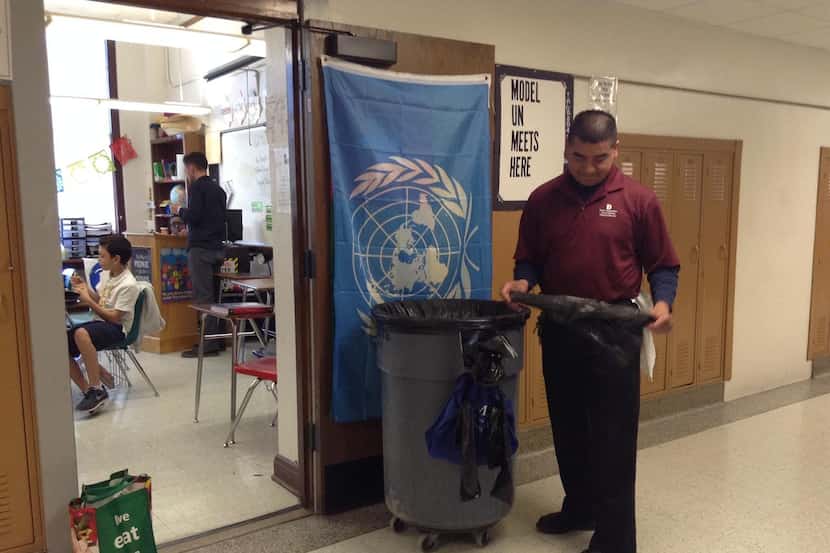 Enrique Méndez se prepara para sacar la basura de un salón de clases en el tercer piso de la...