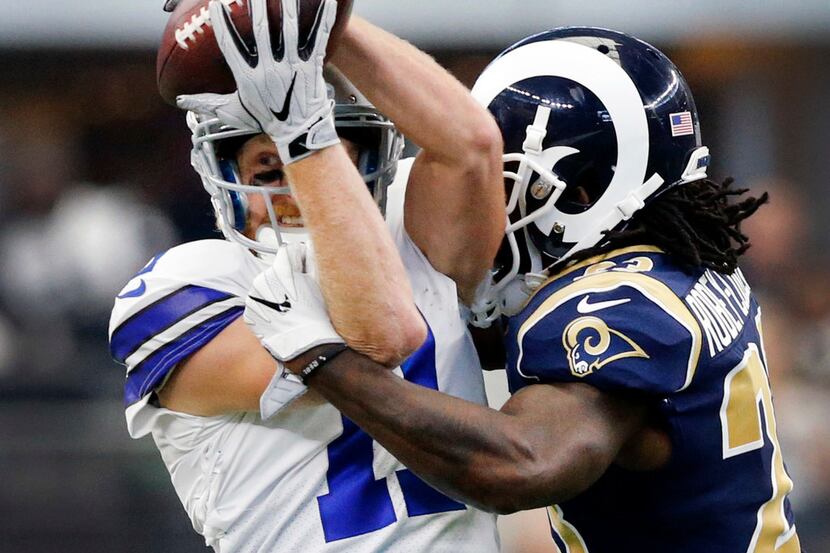 Dallas Cowboys wide receiver Cole Beasley (11) hangs on to a pass as he's hit by Los Angeles...