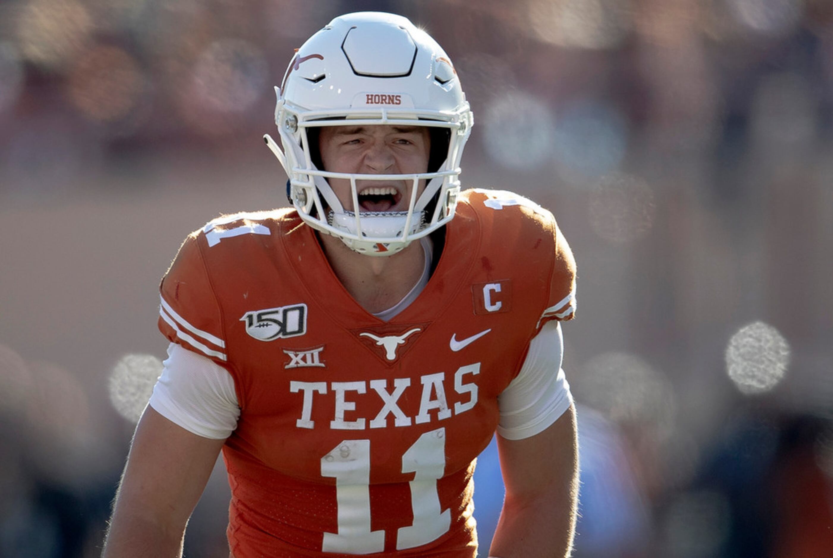 Texas quarterback Sam Ehlinger (11) shouts to teammates against Kansas State during an NCAA...