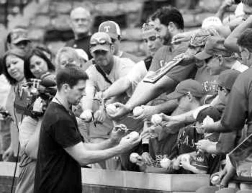  Cliff Lee signed balls for fans before a game between the Texas Rangers and the Minnesota...