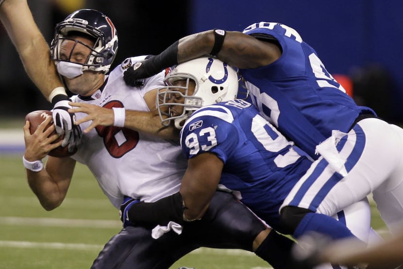 Houston Texans quarterback Matt Schaub, left, is sacked by Indianapolis Colts' Dwight...