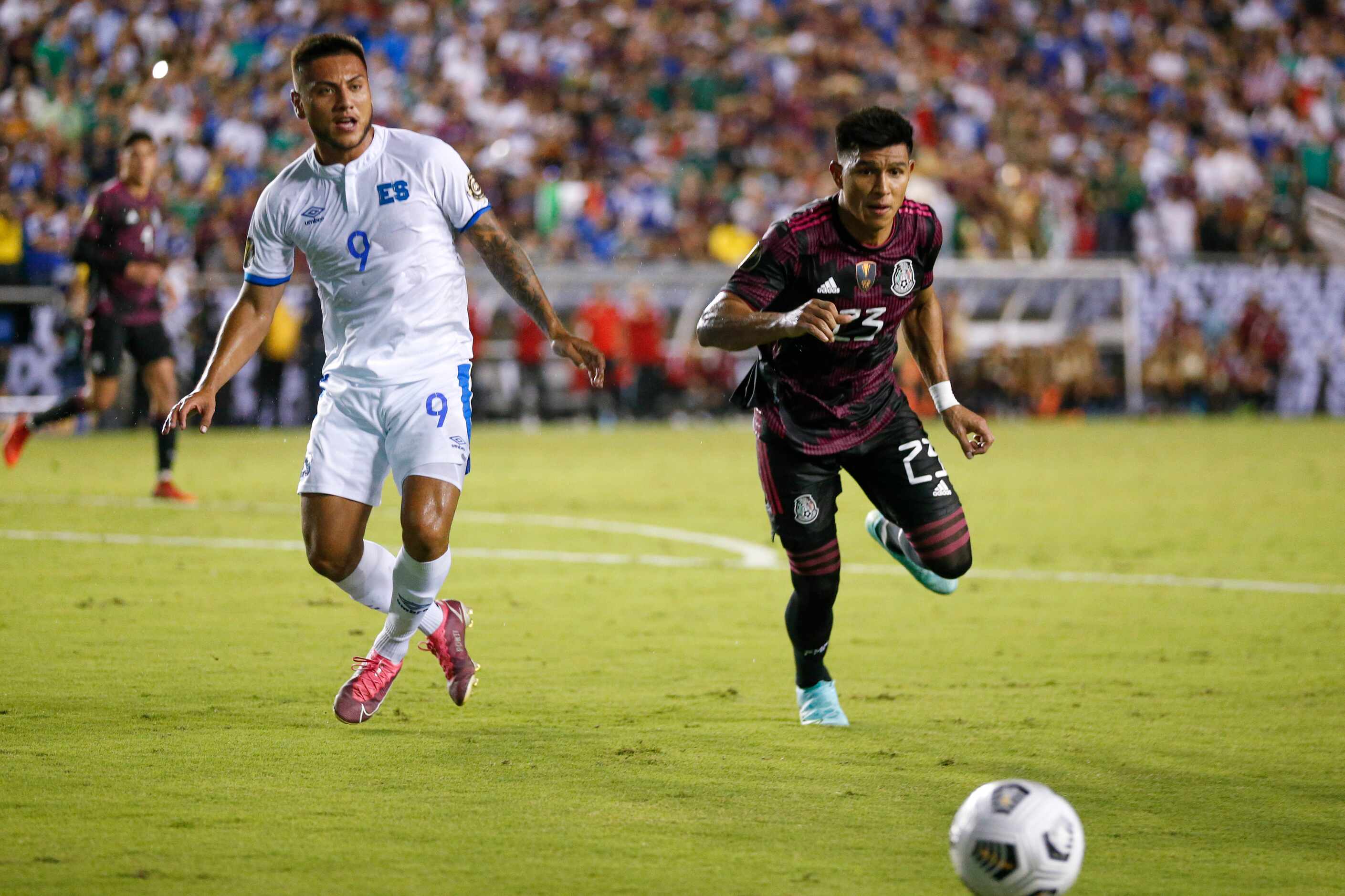Mexico midfielder Jesús Gallardo (23) and El Salvador midfielder Walmer Martínez (9) race to...