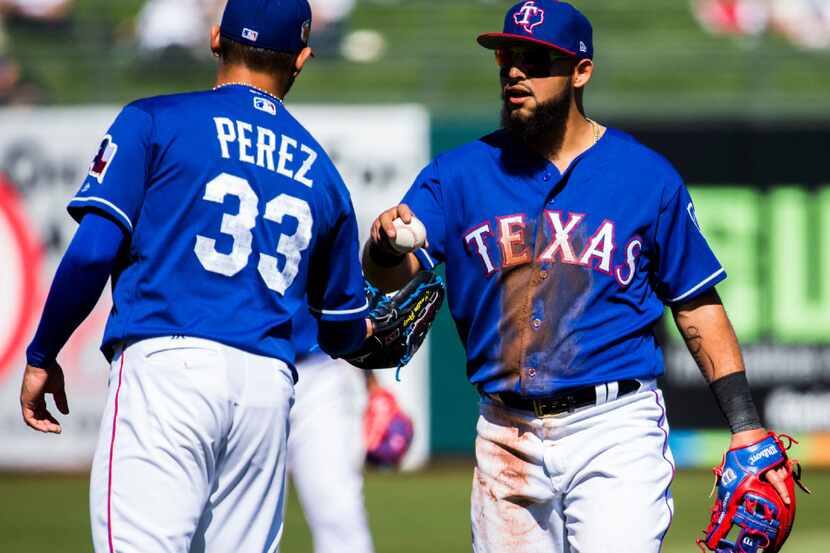 Texas Rangers second baseman Rougned Odor (12) hands the ball to starting pitcher Martin...