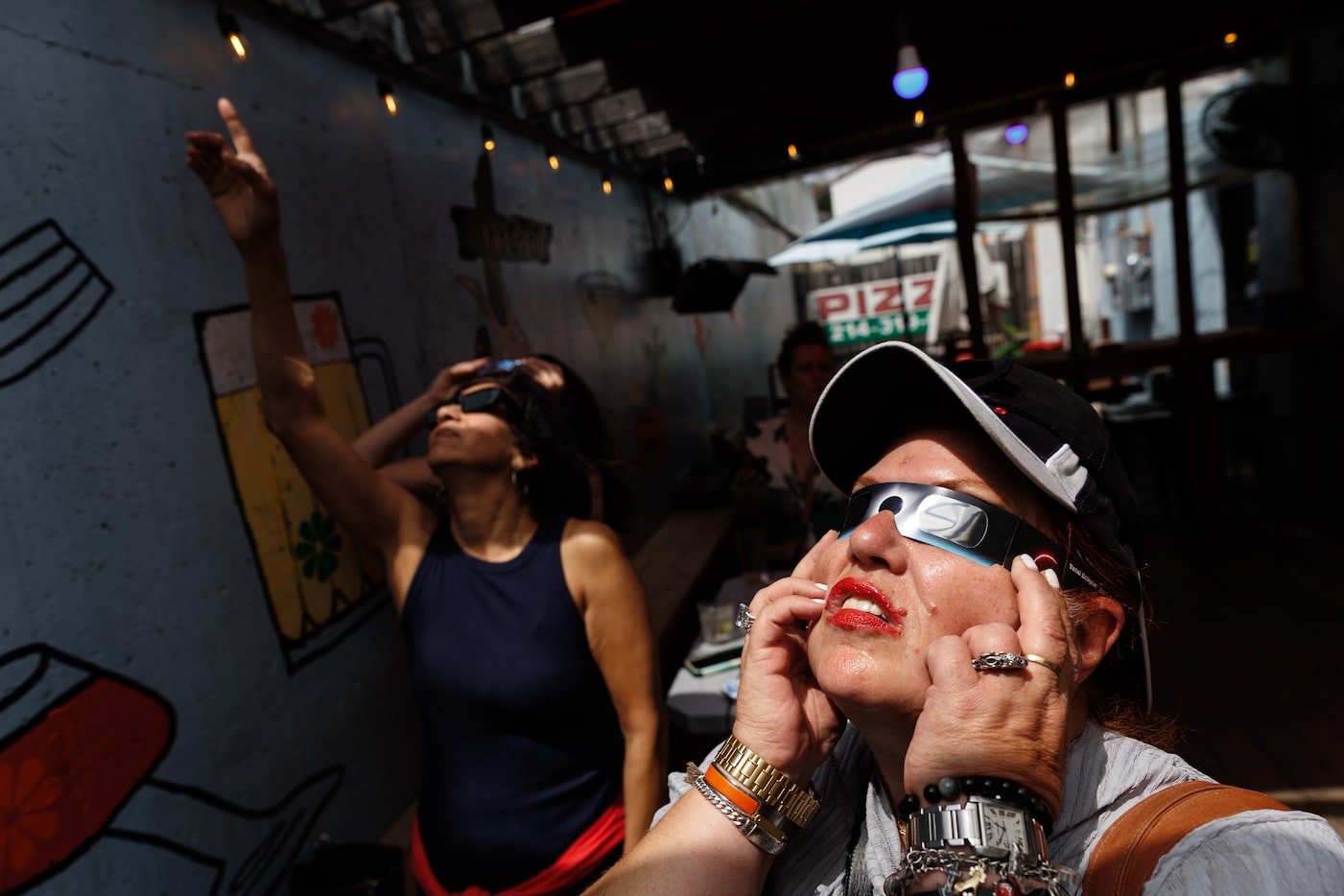 Liz Gutierrez (left and) Sandy Pomeroy look at the eclipse glass before  the total eclipse...