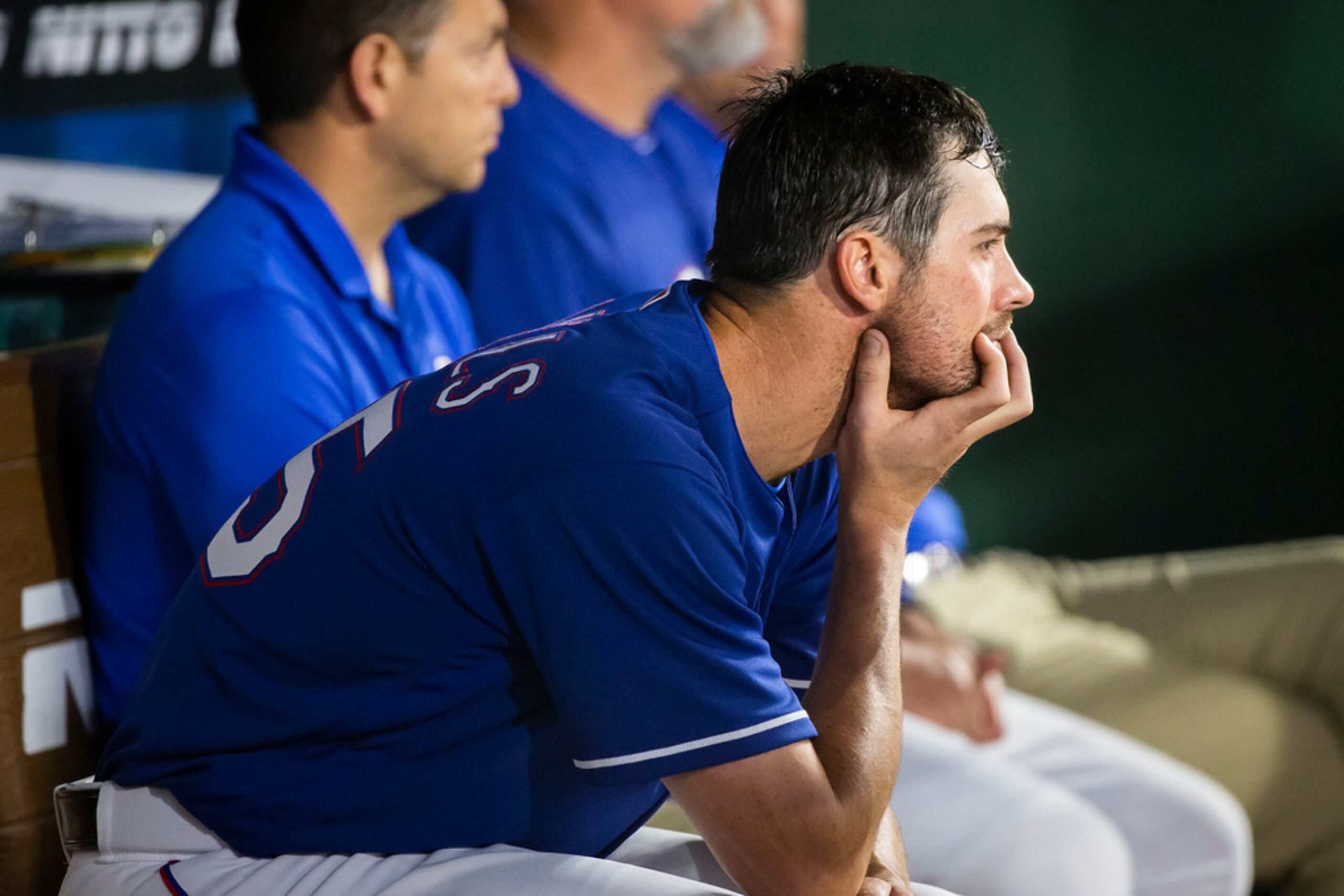 Texas Rangers starting pitcher Cole Hamels watches from the dugout during the seventh inning...