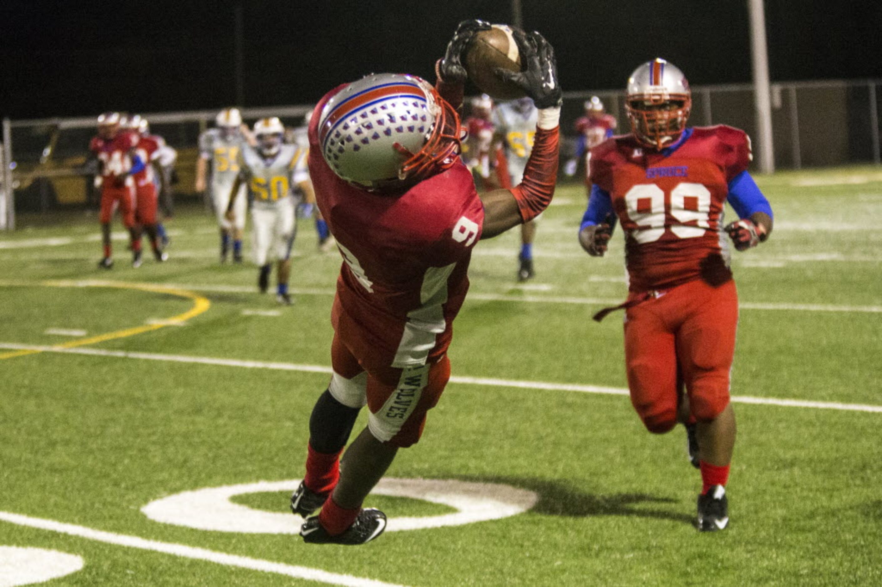 Spruce's Brian Mathis Jr. (9) leaps for an interception during W. W. Samuell's matchup...