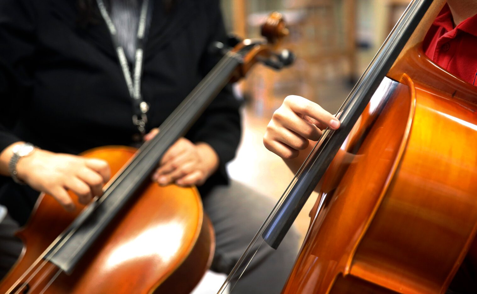 Zach plucks the strings as he learns the basics of the cello during his second lesson.