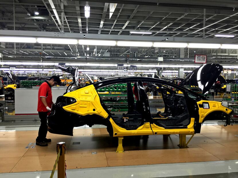 Workers assemble the Forte sedan on the floor of a Kia plant in Nuevo Leon, Mexico, which...