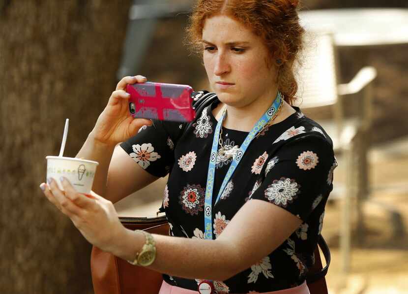 Molly O'Connor takes a photo of her ice cream during the lunchtime opening of Dallas' first...