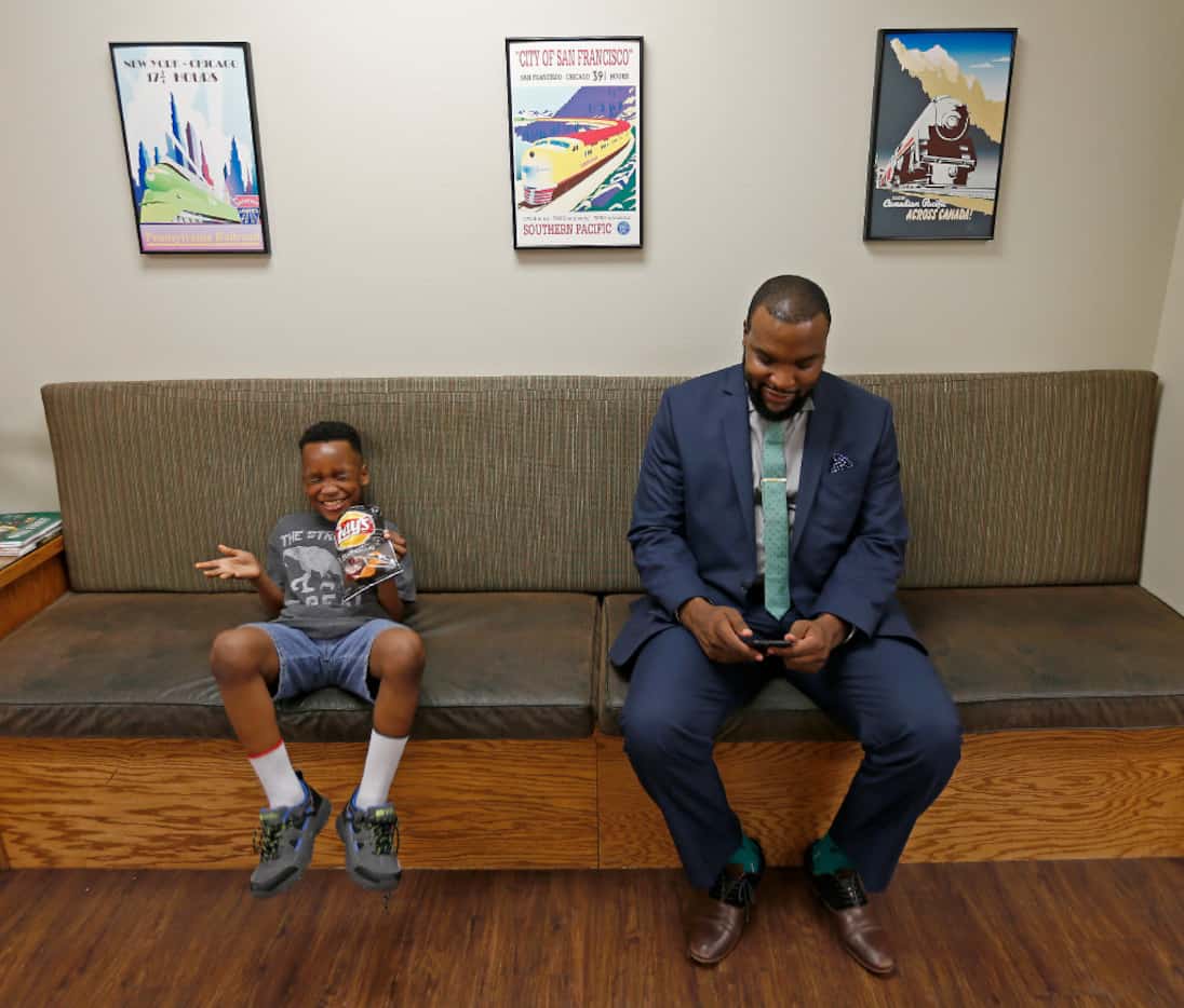 Attorney Lee Merritt shares a laugh with his 7-year-old son, Stacy Merritt Jr., in a waiting...