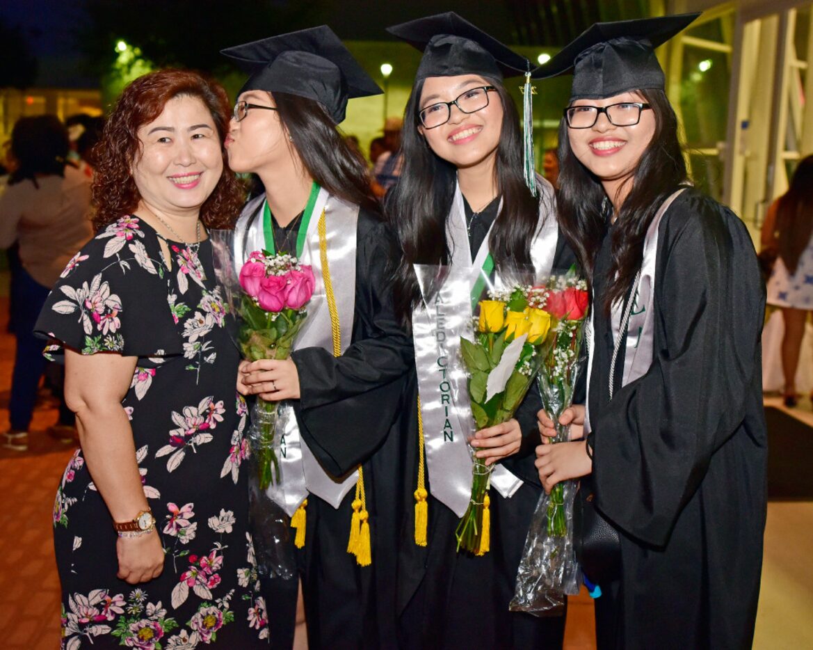 Aunt Dung Tran (left) receives a kiss from salutatorian Han Bao Tran, as valedictorian Tran...