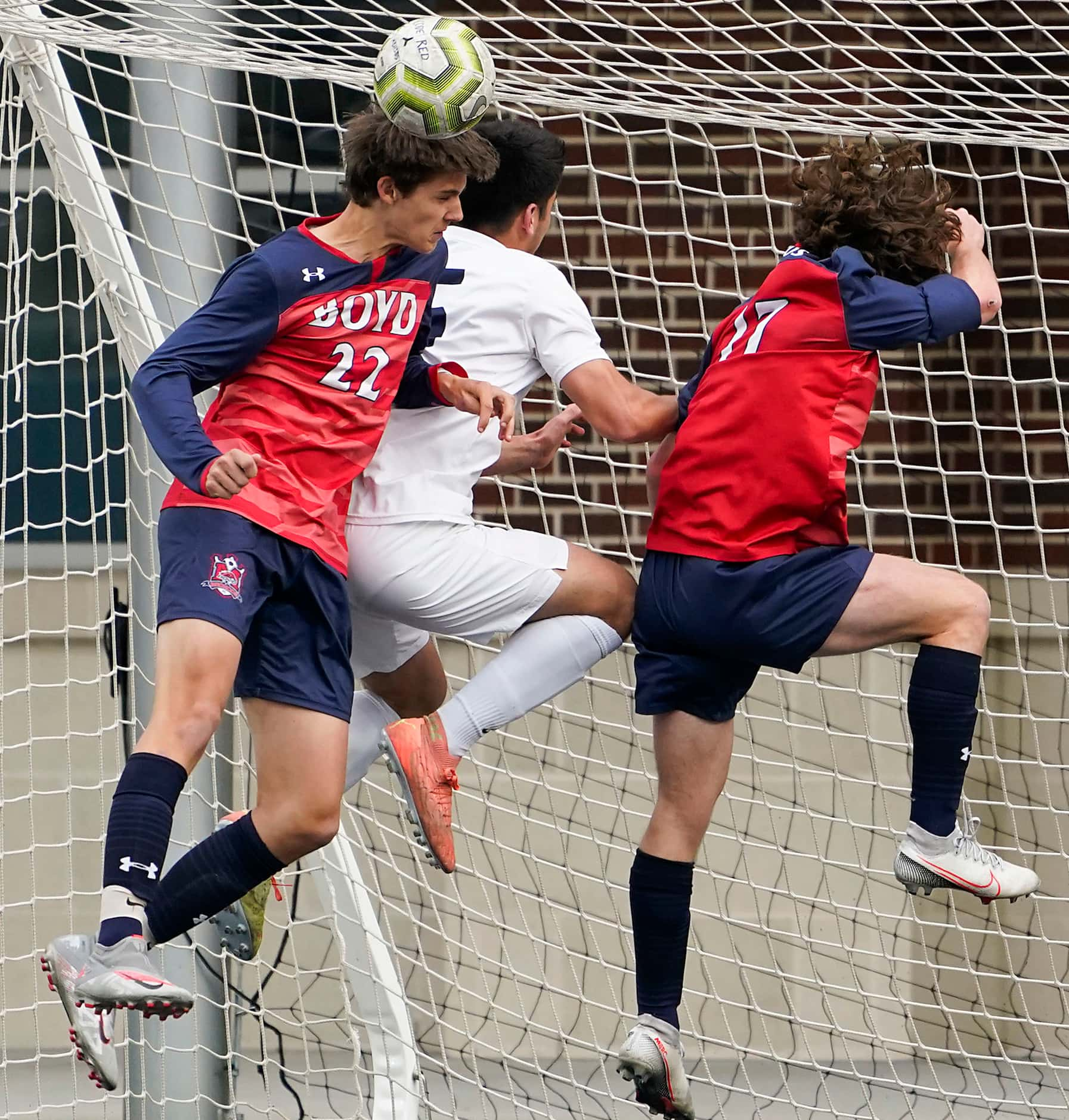 McKinney Boyd defender Braydon Widra (22) fights for a header against Jesuit defender Alec...