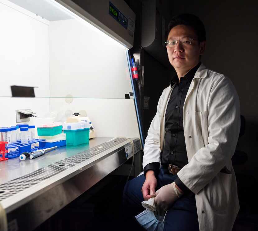 Dr. Zhihao Wu of Southern Methodist University sits next to a biosafety cabinet inside a...