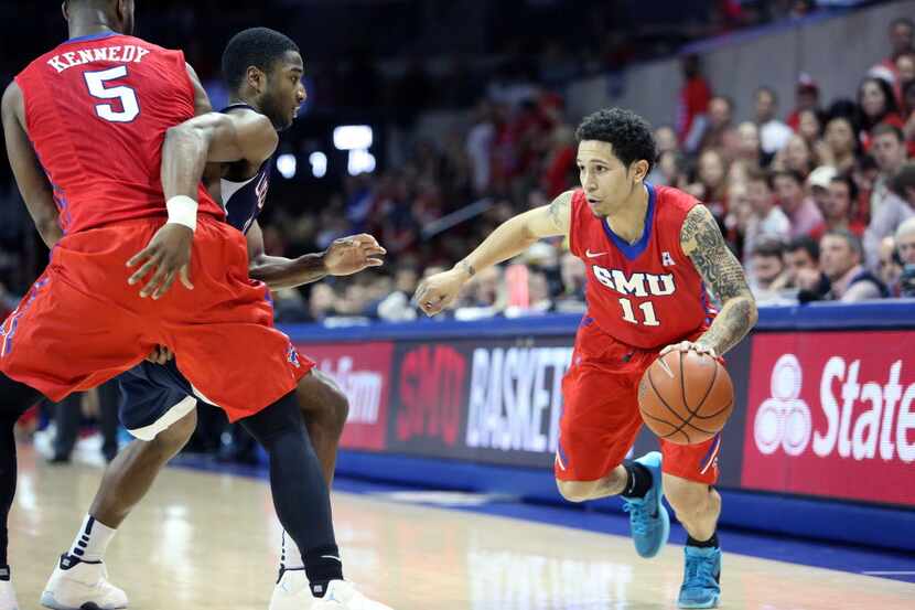 SMU's Nic Moore drives to the hoop around a screen from teammate Markus Kennedy during the...