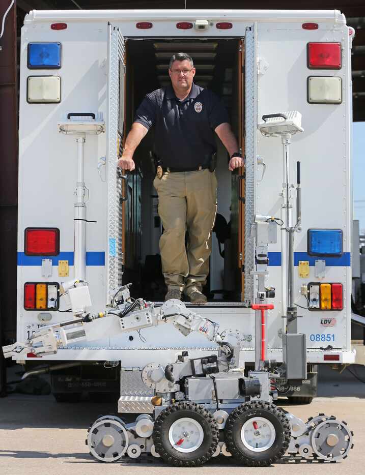 Sgt. Brad Ewell of the Plano Police Department bomb squad poses with one of the department's...