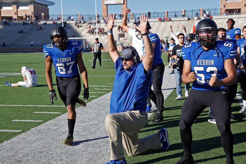 Players on the Hebron sideline erupt around head coach Brian Brazil as they watch an...