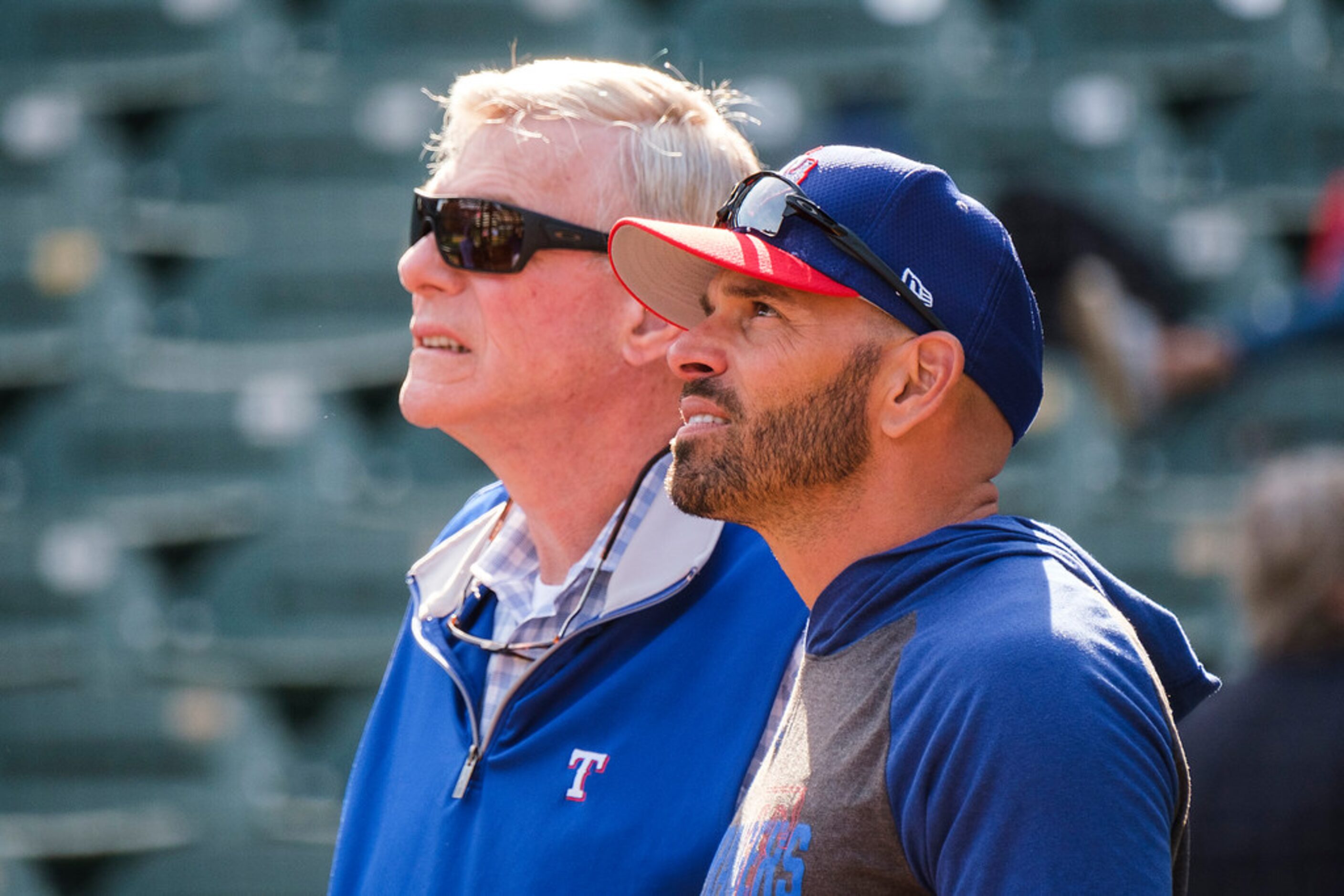 Texas Rangers manager Chris Woodward watches batting practice with team co-chairman Ray C....