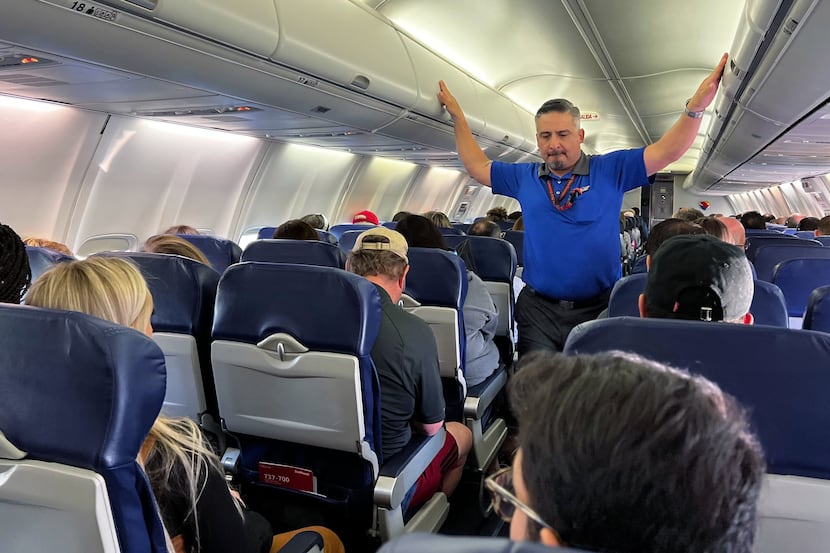 A Southwest Airlines flight attendant checks the overhead bins before the flight left for...