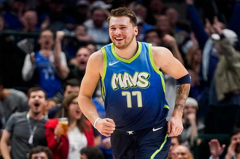 Dallas Mavericks guard Luka Doncic celebrates after throwing down a dunk during the first...
