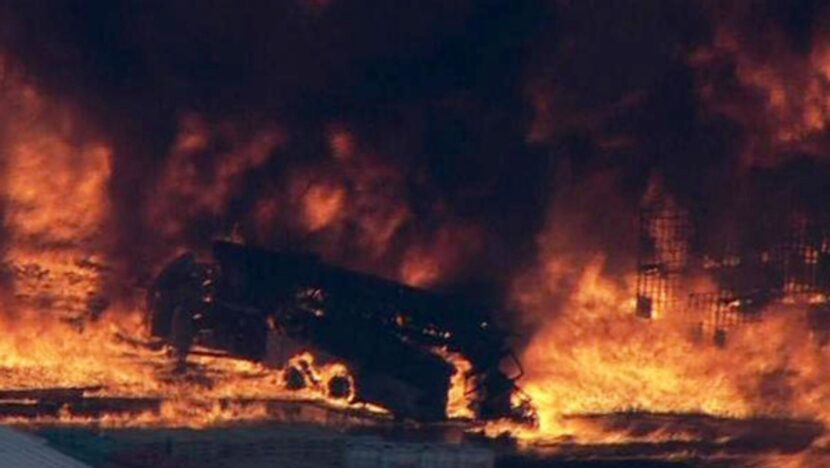 A television image shows a firetruck being engulfed in flames during the blaze, which...