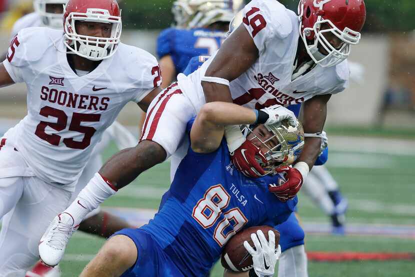 Oklahoma linebacker Eric Striker (19) tackles Tulsa wide receiver Conner Floyd (80) in the...