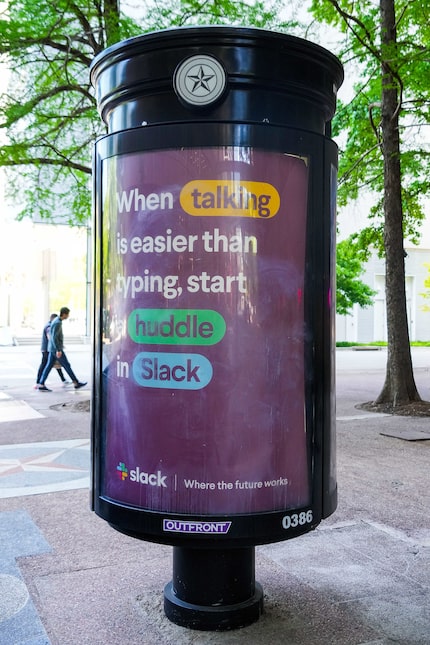 Pedestrians walk past one of the current non-digital kiosks in downtown Dallas, which...