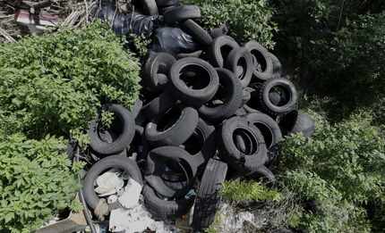 In this photo taken June 22, 2016, a pile of tires sits in a neighborhood near downtown...