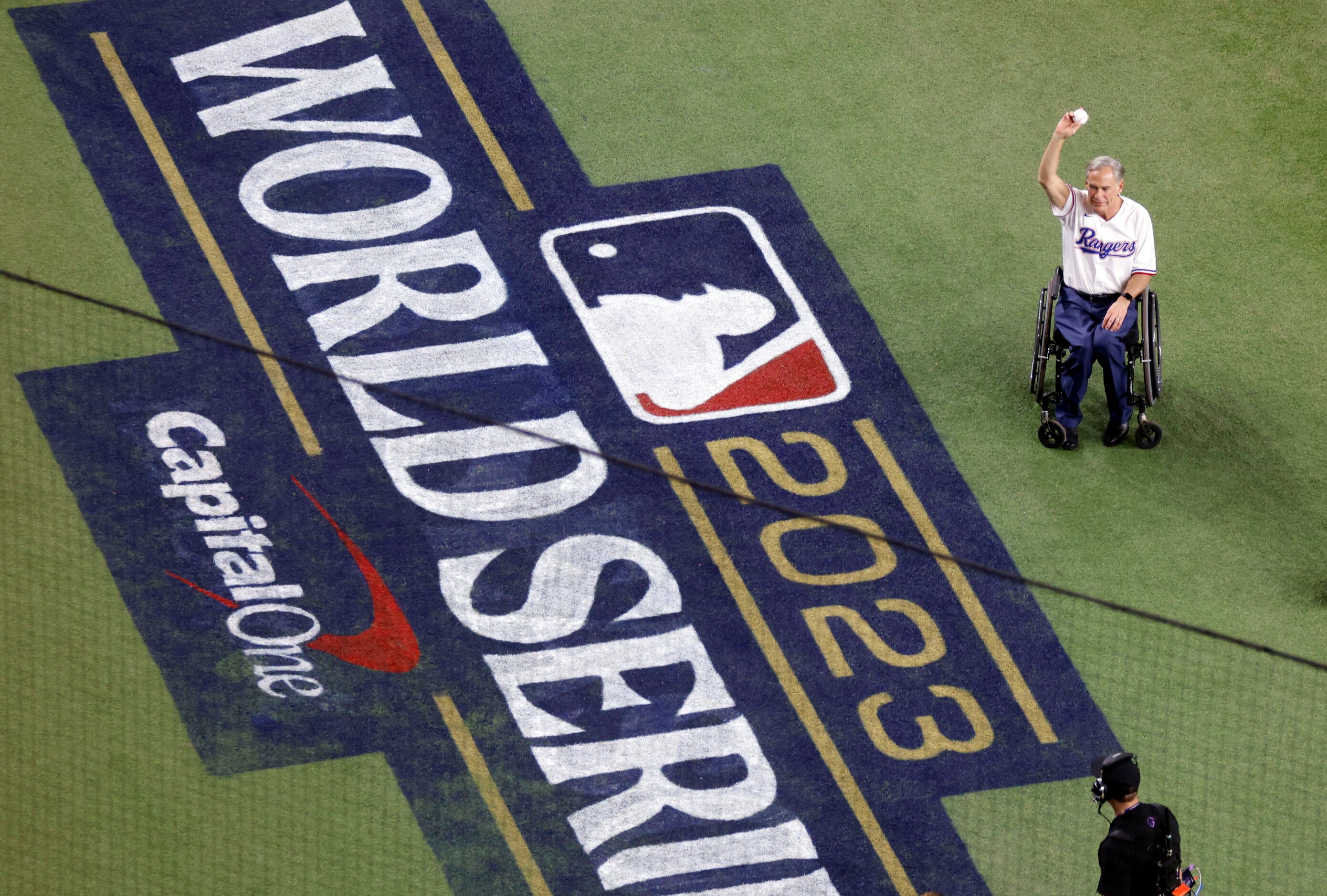 Texas Governor Greg Abbott waves toward the crowd ahead of Game 2 of the World Series...