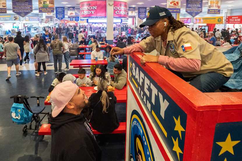 Brian Alonzo, 27, left, asks a member of the State Fair of Texas safety team, unidentified,...
