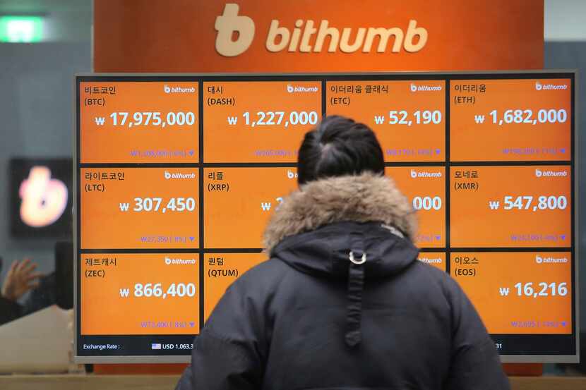 A man watches a screen showing the prices of bitcoin at a virtual currency exchange office...